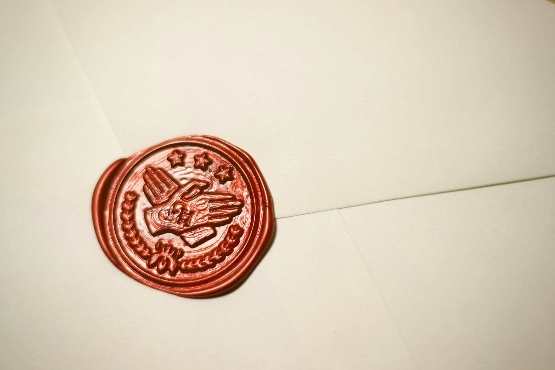 A red wax seal on a cream envelope